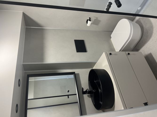 Cuarto de baño moderno en tiny house del Holiday park Eigen Wijze, Países Bajos, con lavabo negro.