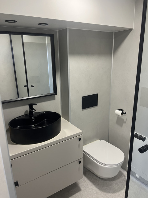 Moderne badeværelse i et tiny house ved Holiday park Eigen Wijze, Holland, med sort vask og toilet.