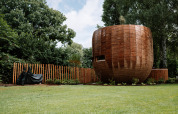 Rond houten tiny house met hek en gazon in Recreation Park Den Blanken, Nederland.
