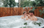 Koppel ontspant met wijn in een hot tub bij The Nutshell, Recreatiepark Den Blanken, Nederland.