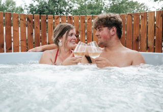 Koppel in bubbelbad met champagneglazen bij The Nutshell, Recreation Park Den Blanken, Nederland.