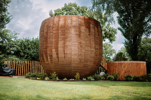 Rond houten tiny house The Nutshell met hot tub en sauna in park Den Blanken, Nederland.
