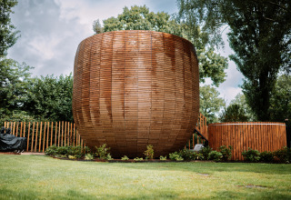 Unikt rundt træhus kaldet The Nutshell med udendørs spabad og sauna i Den Blanken park, Holland.