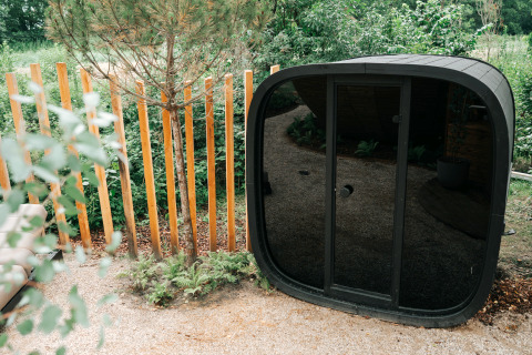 Black sauna pod next to The Nutshell tiny house and hot tub at Recreation Park Den Blanken, the Netherlands.