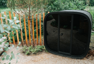 Zwarte saunacabine bij The Nutshell tiny house en hottub in Recreatiepark Den Blanken, Nederland.