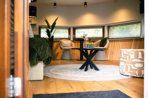 Moderne stue i The Nutshell, et tiny house med varme farver og hyggelig indretning i Holland.