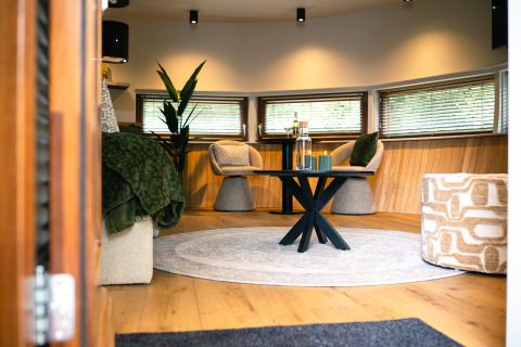 Gezellige zithoek in The Nutshell tiny house met hottub en sauna op Recreatiepark Den Blanken, Nederland.