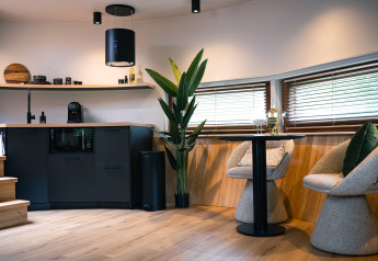 Moderne indretning i The Nutshell tiny house med køkken, spisehjørne og store vinduer i Holland.