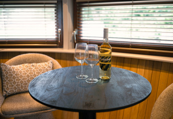 Ein Tisch mit zwei Weingläsern und einer Weinflasche im Tiny House The Nutshell im Den Blanken Park.