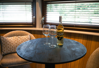 Tafel met twee wijnglazen en een fles wijn in The Nutshell bij Den Blanken in Nederland.