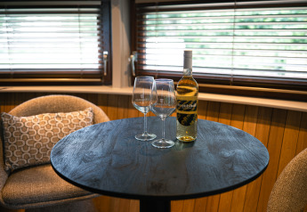 Tafel met twee wijnglazen en een fles wijn in The Nutshell bij Den Blanken in Nederland.