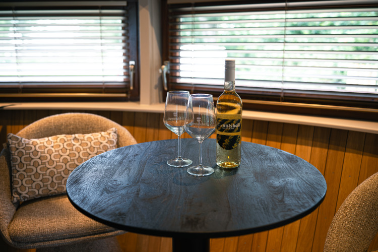 Mesa con dos copas y una botella de vino en la tiny house The Nutshell en Den Blanken, Países Bajos.