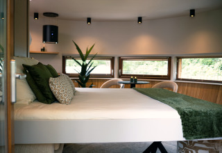 Modern bedroom inside The Nutshell tiny house with green decor at Recreation Park Den Blanken, Netherlands.