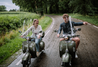 To personer på scootere nyder en tur på landet nær The Nutshell, Rekreatiepark Den Blanken, Holland.