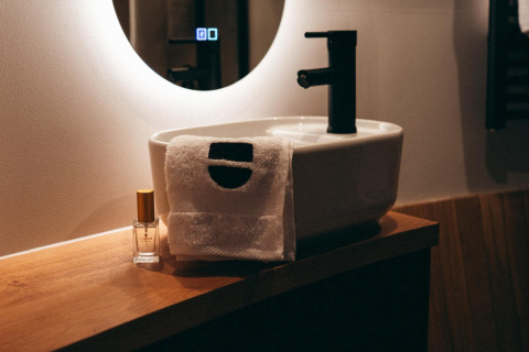 Moderne lavabo met handdoek en parfumfles in The Nutshell, Den Blanken, Nederland.