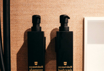 Zwei schwarze Spenderflaschen mit den Aufschriften „mynutshell shampoo“ und „mynutshell bodywash“ an der Wand.