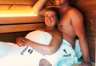 Two people relax in the sauna at The Nutshell tiny house with hot tub at Den Blanken, Netherlands.