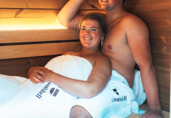 Deux personnes se détendent dans le sauna de The Nutshell, tiny house avec spa à Den Blanken, Pays-Bas.
