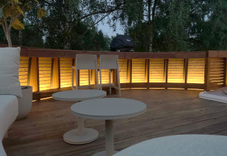Evening deck at The Nutshell in Den Blanken Park, Netherlands, warmly lit with cozy outdoor furniture.