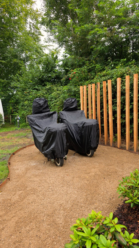 Two covered lounge chairs by a wooden fence in the garden of The Nutshell at Den Blanken, Netherlands.