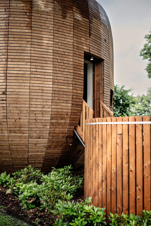 Modern round tiny house with wood panels, hot tub, and sauna at Recreation Park Den Blanken, Netherlands.