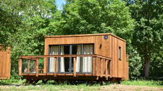 Cabaña de madera en Cocoon de la Semois, Hameau de la Semois, Bélgica, rodeada de árboles verdes.