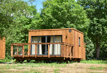 Houten lodge in Cocoon de la Semois, Hameau de la Semois, België, omringd door weelderige bomen.