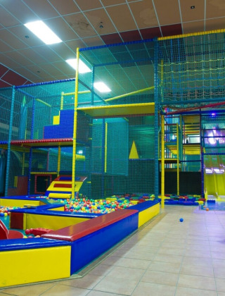 Overdekte speelhoek met ballenbad, klimtoestellen en glijbanen in De Scherpenhof, Gelderland.