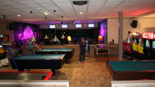 Fritidsområde i Recreatiepark de Scherpenhof med poolborde, spillemaskiner og bowlingbaner i Gelderland.
