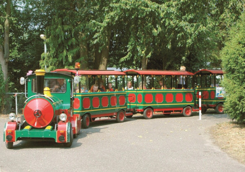 Børnetog kører gennem træfyldt område i Recreatiepark de Scherpenhof, Gelderland, Holland.
