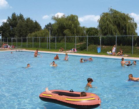 Families and children enjoy swimming and relaxing in the outdoor pool at Recreatiepark de Scherpenhof.