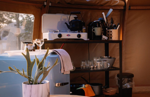 Indoor kitchen setup at Panorama Dome, Camping Vinkenhof, Netherlands, featuring stove and utensils.