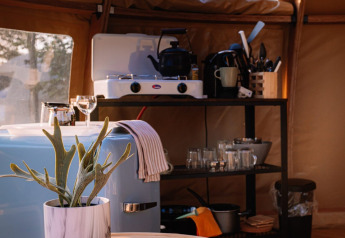 Cucina interna nella Panorama Dome di Camping Vinkenhof, Paesi Bassi, con fornello e utensili da cucina.