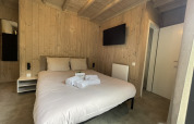 Modernes Schlafzimmer in der Cocoon de la Semois Lodge, Hameau de la Semois, Belgien, mit Holzverkleidung.