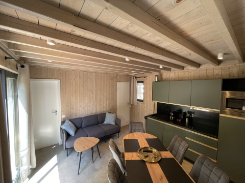 Modern living and kitchen area in a wood-paneled Ecolodge 2-bedroom at Hameau de la Semois, Belgium.
