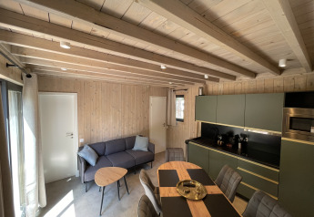 Sala de estar y cocina modernas en una ecolodge de dos habitaciones en Hameau de la Semois, Bélgica.