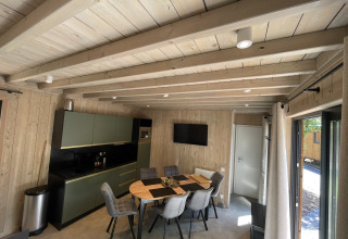 Moderne keuken en eetruimte met houten lambrisering in Ecolodge Hameau de la Semois, België.