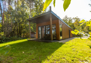 Lodge bien-être moderne en bois avec terrasse, situé dans la verdure au Vakantiepark De Wiltzangh aux Pays-Bas.