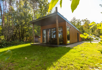 Moderna cabaña de bienestar con terraza cubierta, rodeada de naturaleza en Vakantiepark De Wiltzangh, Países Bajos.