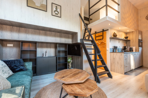 Indretning af et lille hus ved Tiny Borg, Vakantiepark De Wiltzangh, med hems, trappe og åbent køkken.