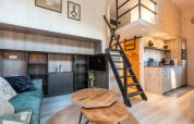 Indretning af et lille hus ved Tiny Borg, Vakantiepark De Wiltzangh, med hems, trappe og åbent køkken.