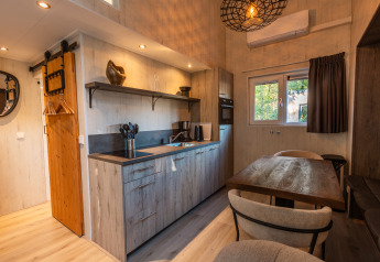 Mini casa moderna e accogliente con cucina e tavolo da pranzo al Vakantiepark De Wiltzangh, Paesi Bassi.
