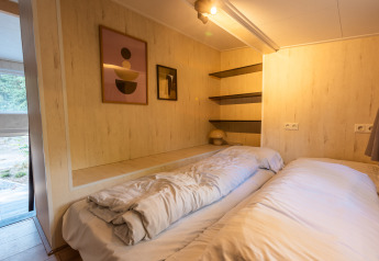 Soveværelse i Tiny Borg, Vakantiepark De Wiltzangh, Nederlandene, med moderne indretning og dobbeltseng.