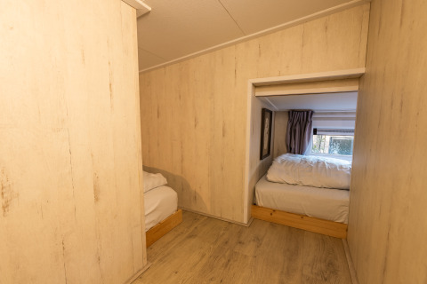 Vista interna dell'area notte della tiny house Tiny Borg presso Vakantiepark De Wiltzangh, Paesi Bassi.