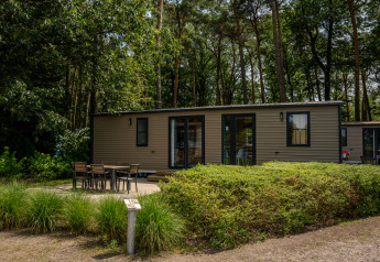 Casa mobile Extra Luxe al Familiepark Goolderheide in Belgio, immersa negli alberi e con area esterna.