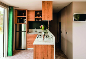 Cucina moderna e luminosa in una casa mobile Extra Luxe Stacaravan al Familiepark Goolderheide, Belgio, con finiture in legno.