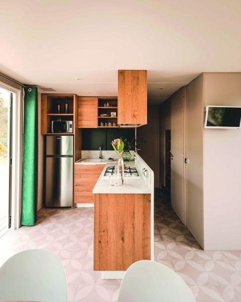 Moderne køkken i mobilhome på Extra Luxe Stacaravan, Familiepark Goolderheide, Belgien, med lyse træelementer.