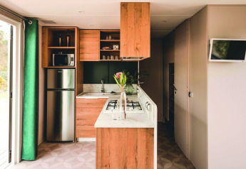 Cuisine moderne d’un mobil-home Extra Luxe Stacaravan à Familiepark Goolderheide, Belgique, avec des touches boisées.