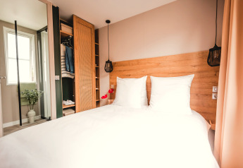Camera da letto luminosa e moderna con letto matrimoniale in Extra Luxe Stacaravan al Familiepark Goolderheide, Belgio.