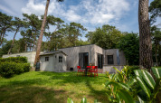 Chalet al Familiepark Goolderheide in Belgio circondato da alberi e giardino con area salotto esterna.